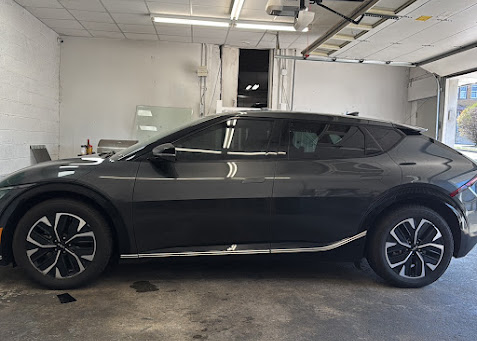 Black Kia EV6 with tinted windows in the install bay